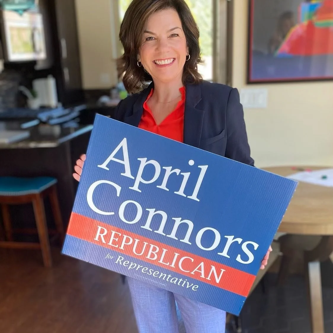 Rep. April Connors holding a campaign yard sign in Washington's 8th Legislative District
